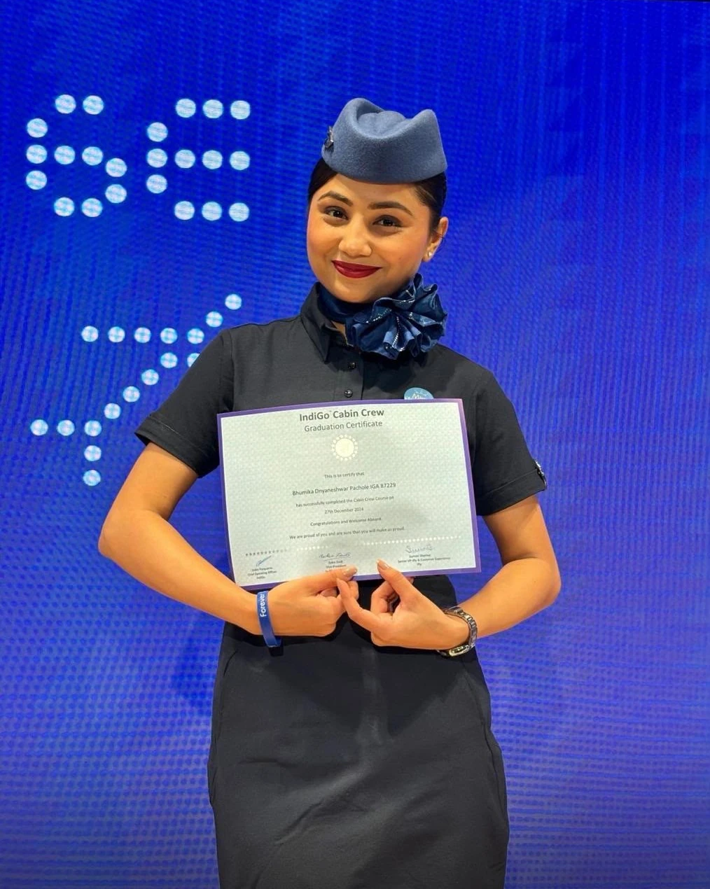 Bhumika in her IndiGo cabin crew uniform holding her graduation certificate