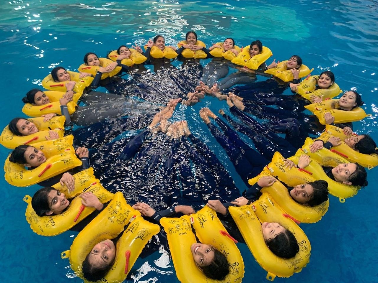 Students in life vests forming a survival circle during water evacuation training